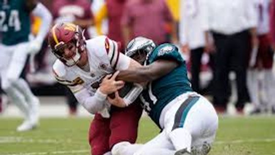 Philadelphia Eagles defensive tackle Javon Hargrave (97) pulls down Washington Commanders quarterback Carson Wentz (11) during the second half of an NFL football game, Sunday, Sept. 25, 2022, in Landover, Md.