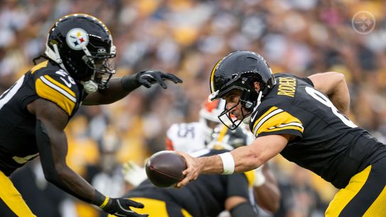 Steelers rookie running back Kaleb Johnson (20) prepares to receive a handoff from veteran quarterback Aaron Rodgers (8) during a regular season game against the Cleveland Browns. Steelers rookie running back Kaleb Johnson (20) prepares to receive a handoff from veteran quarterback Aaron Rodgers (8) during a regular season game against the Cleveland Browns.