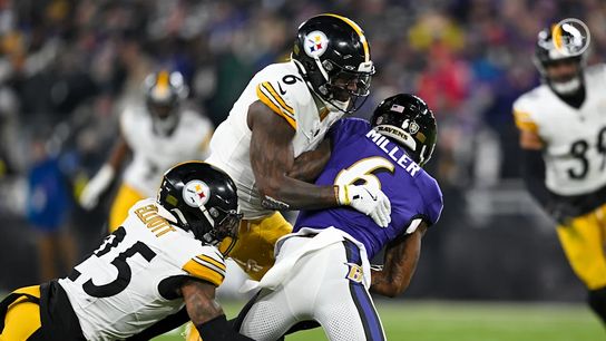 Pittsburgh Steelers' DeShon Elliott and Patrick Queen making a tackle during playoff game in Baltimore in 2024.