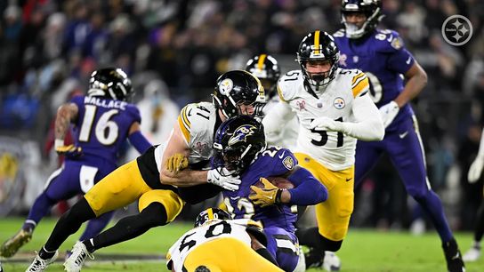 Pittsburgh Steelers' Payton Wilson and Elandon Roberts make a tackle on Ravens' running back Derrick Henry in 2024.